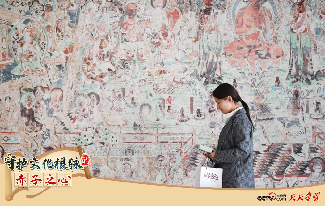 2023年4月25日,敦煌研究院文物數(shù)字化保護(hù)團(tuán)隊(duì)創(chuàng)意營銷人員廖雪婷從一幅高保真復(fù)制壁畫前走過。